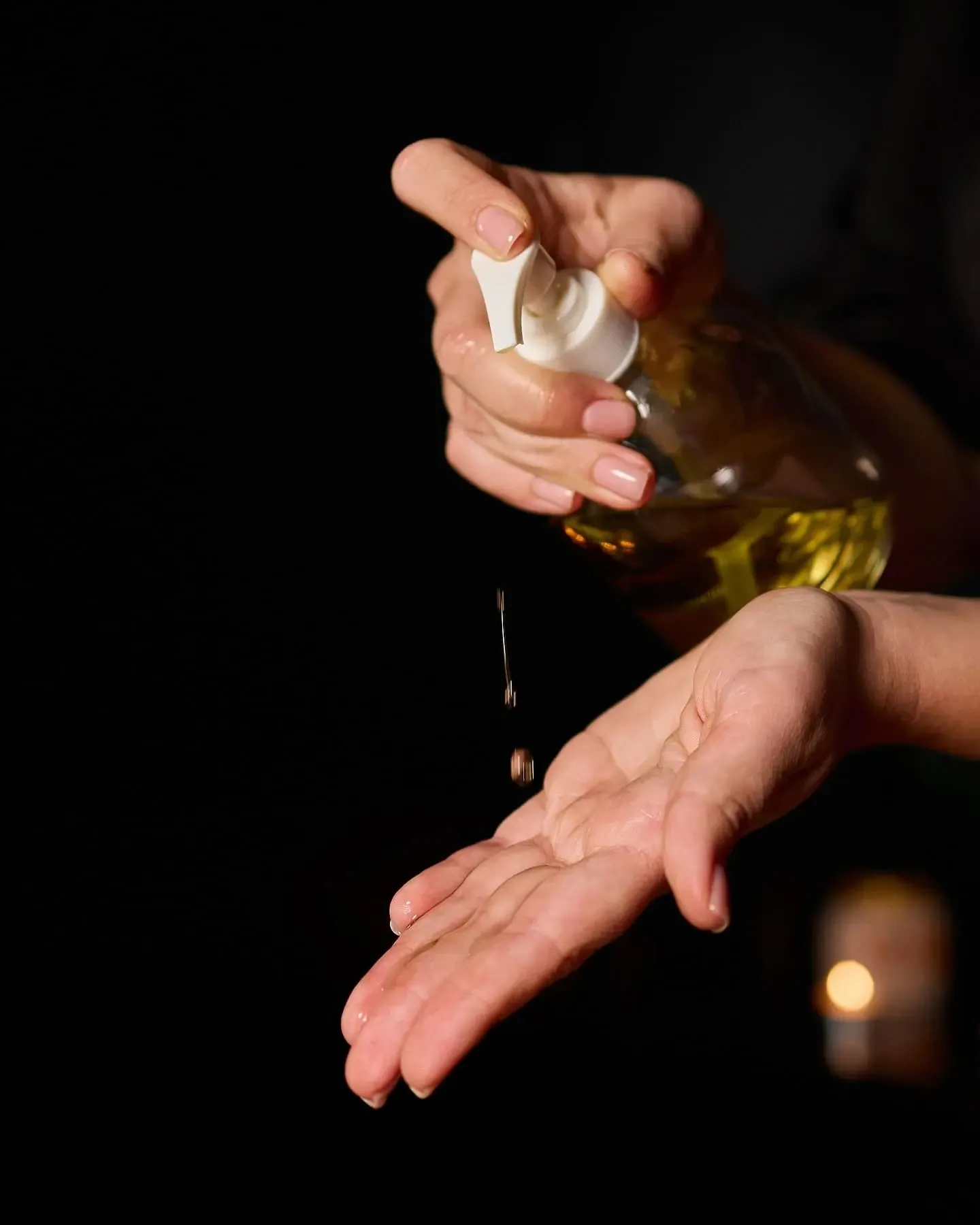 Therapist pouring warm aroma oil into her palm